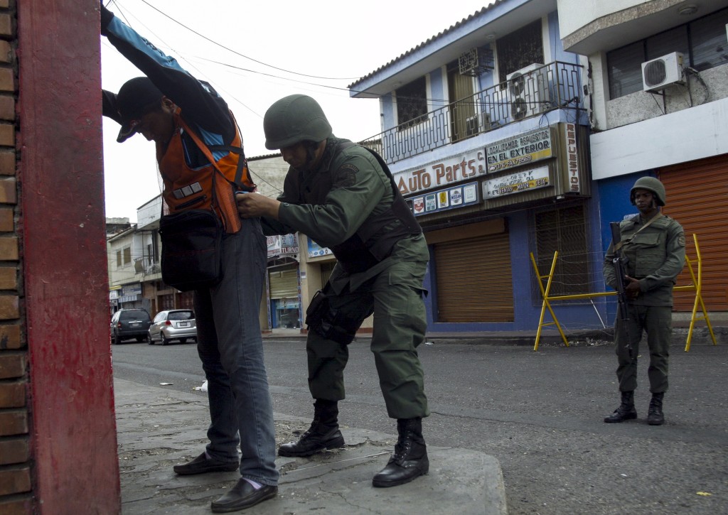 A man is frisked by a Venezuelan soldier, at a checkpoint close to the border with Colombia, as part of a special deployment, at San Antonio in Tachira state, Venezuela August 22, 2015. Venezuela's closure of two border crossings with Colombia hurts innocent people, Colombia's President Juan Manuel Santos said on Saturday, adding that he hoped to speak to his Venezuelan counterpart Nicolas Maduro to find a solution. Maduro closed the crossings on Wednesday after a shootout between smugglers and troops left three soldiers wounded. He declared a 60-day state of emergency in five border municipalities on Friday. REUTERS/Carlos Eduardo Ramirez