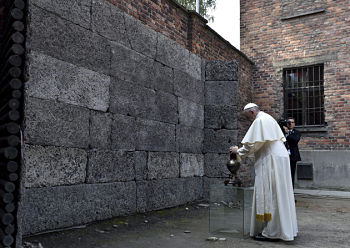 OSW06 OSWIECIM (POLONIA) 29/07/2016.- El papa Francisco enciende una vela frente al "muro de la muerte" en el que fueron ejecutados miles de judÌos, durante su visita al campo de concentraciÛn nazi de Auschwitz, en Oswiecim, Polonia, hoy, 29 de julio de 2016. EFE/RADEK PIETRUSZKA PROHIBIDO SU USO EN POLONIA