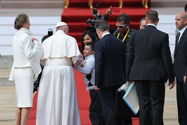 Niño se salta el protocolo para entregarle una bandera de Venezuela al Papa | Foto: EFE